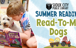 A young boy reads a book to a white dog at the Sioux City Public Librarys Summer Reading Read-To-Me Dogs program. The banner features playful text and cartoon donuts with books.